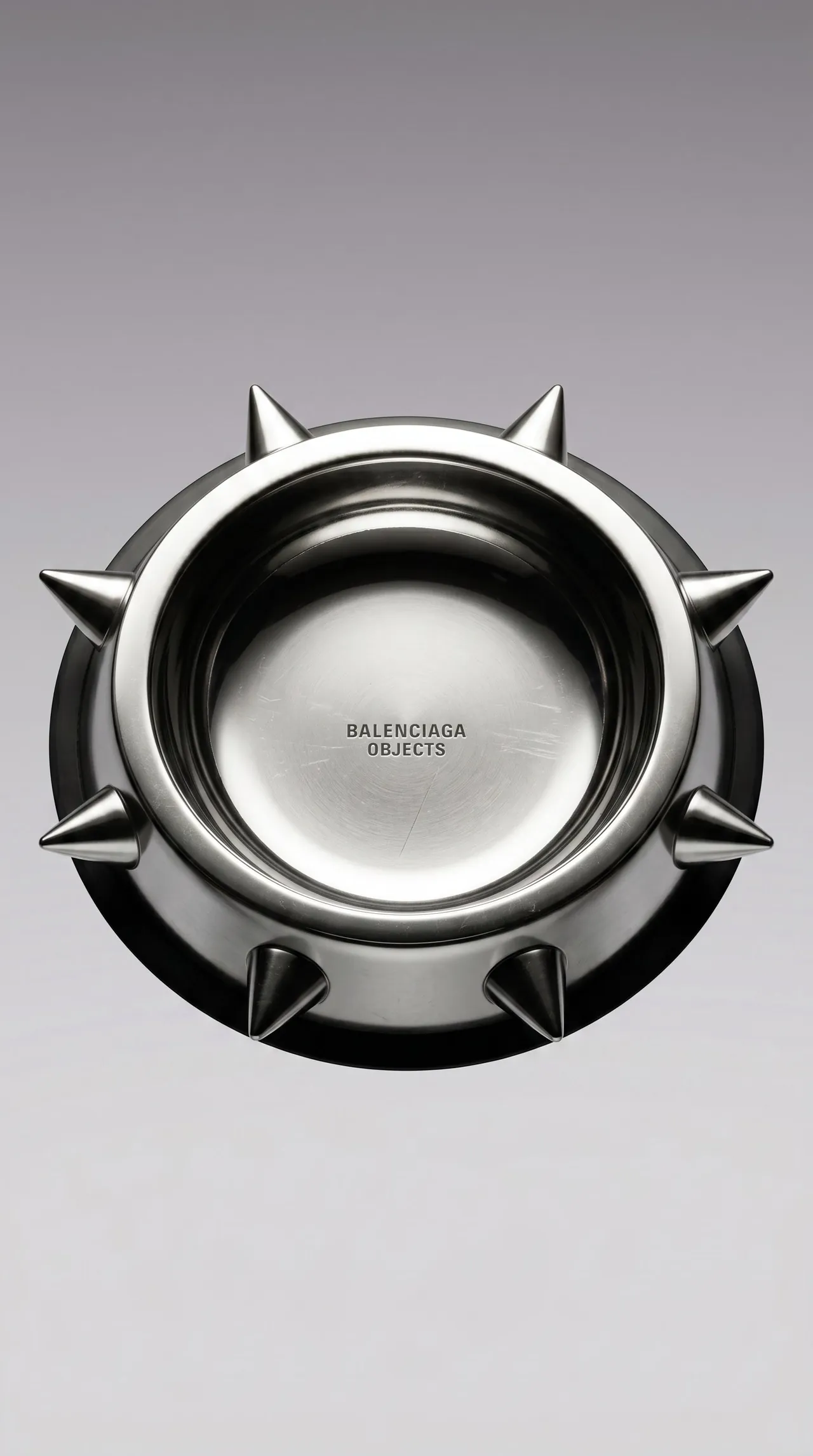Polished steel Balenciaga Spike Bowl ringed with spikes, seen from above on grey
