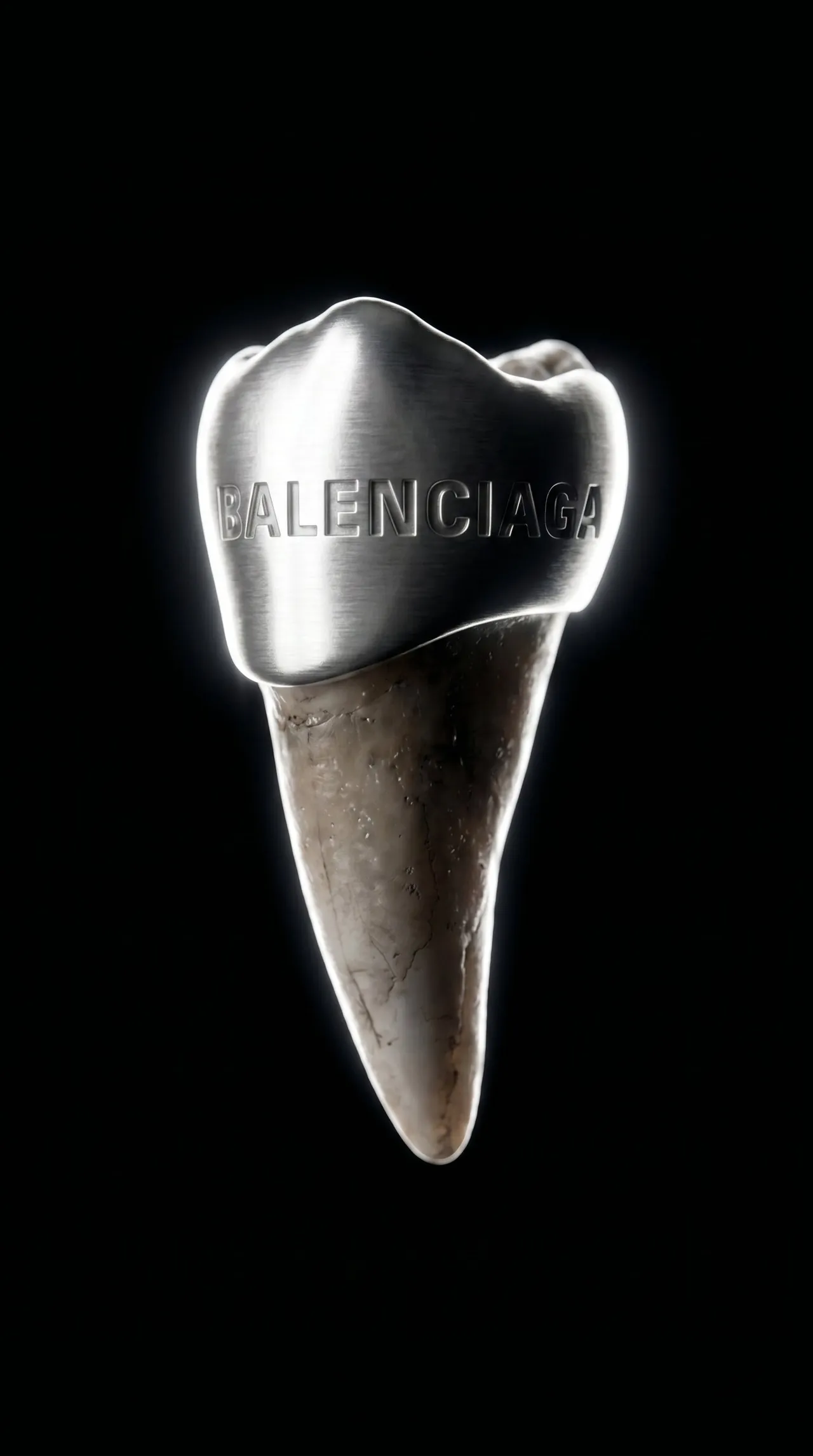 Single tooth capped in silver engraved with the Balenciaga name, on black