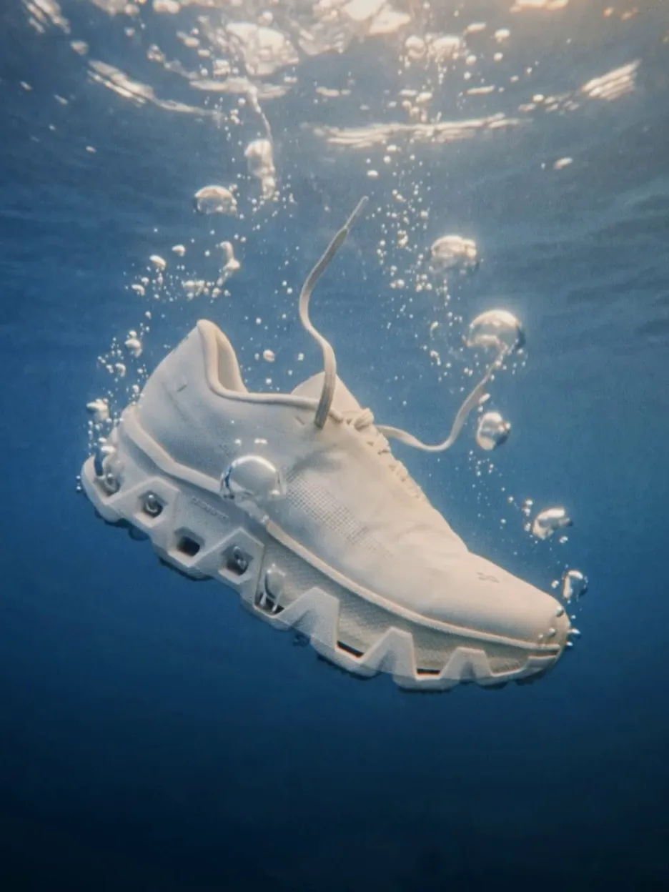 White On running shoe sinking underwater in a trail of bubbles